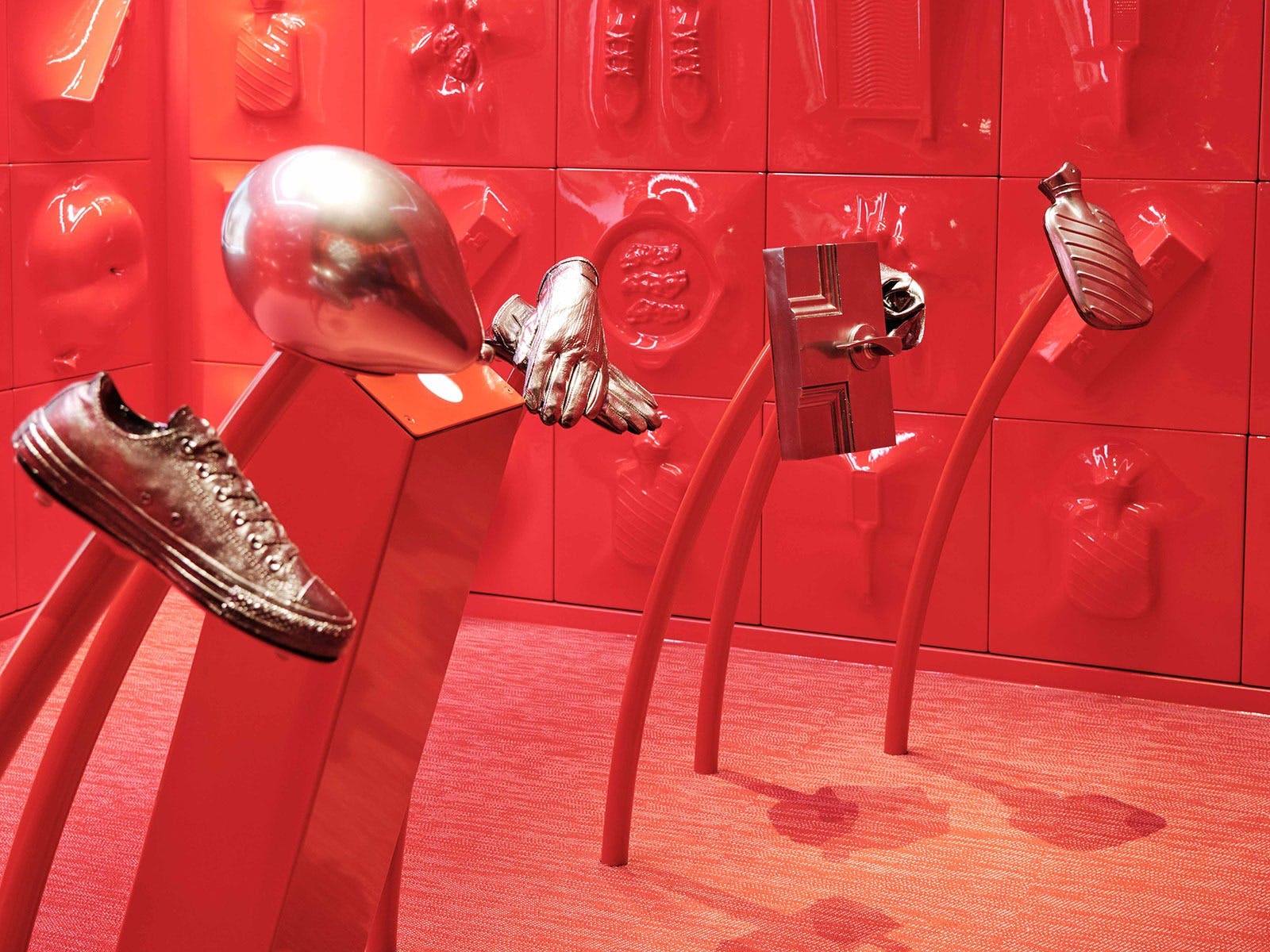 A red room with silver objects on stands