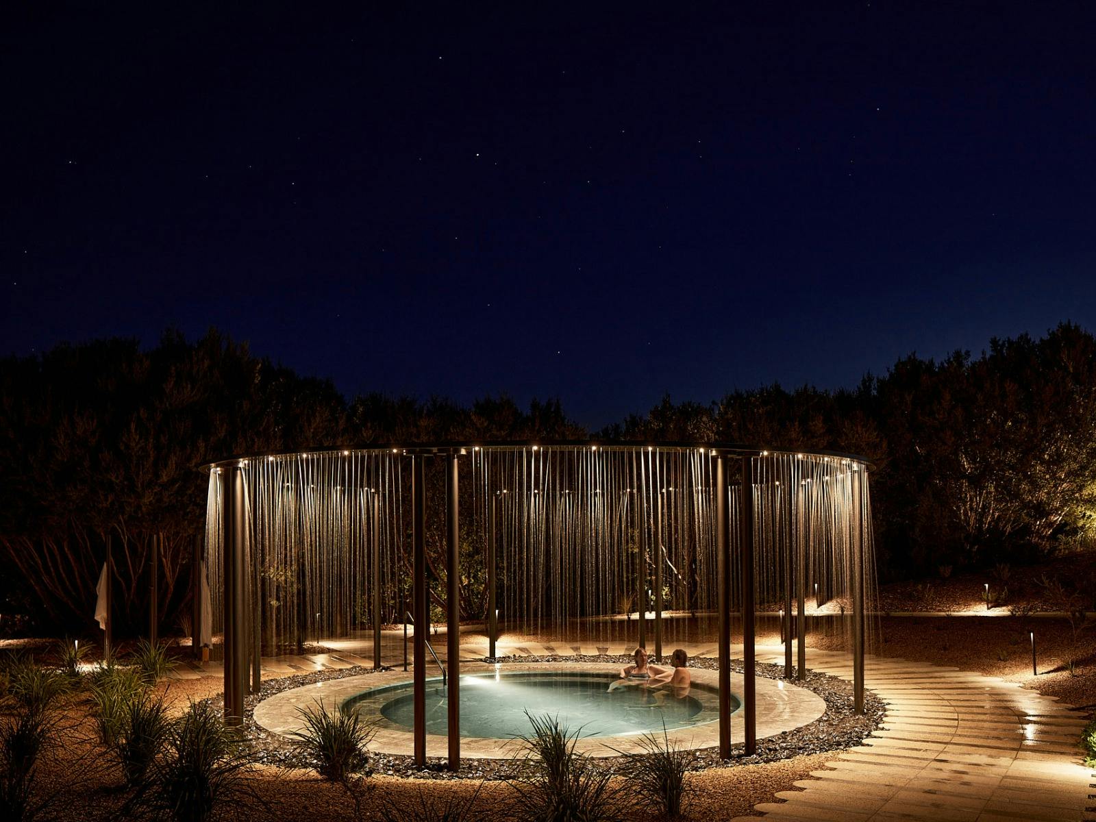 Couple bathing in geo thermal pool at night