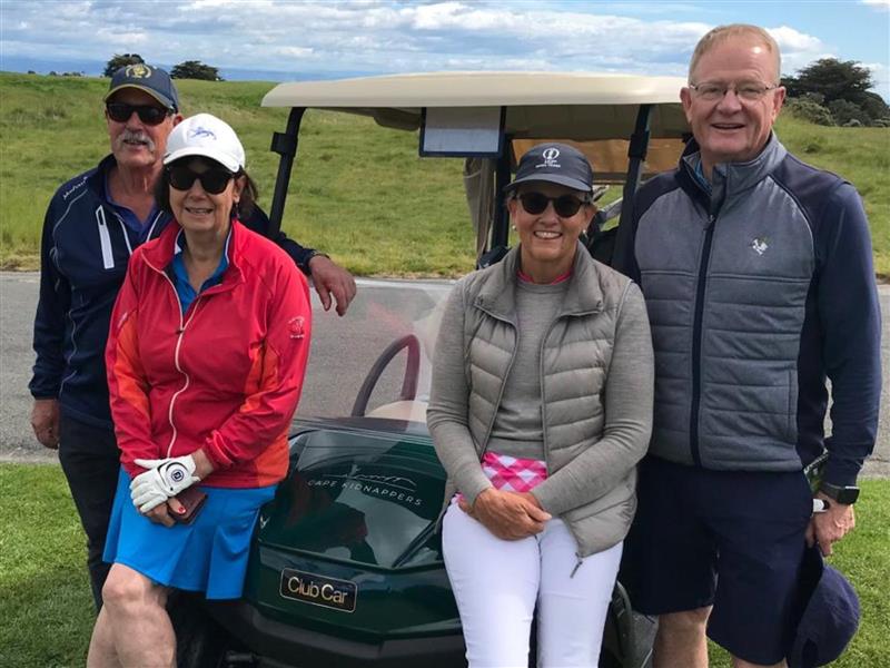 Golfers standing in front of a cart